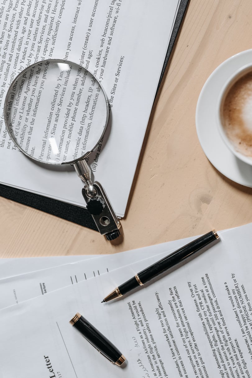 Silver and Black Magnifying Glass on White Paper